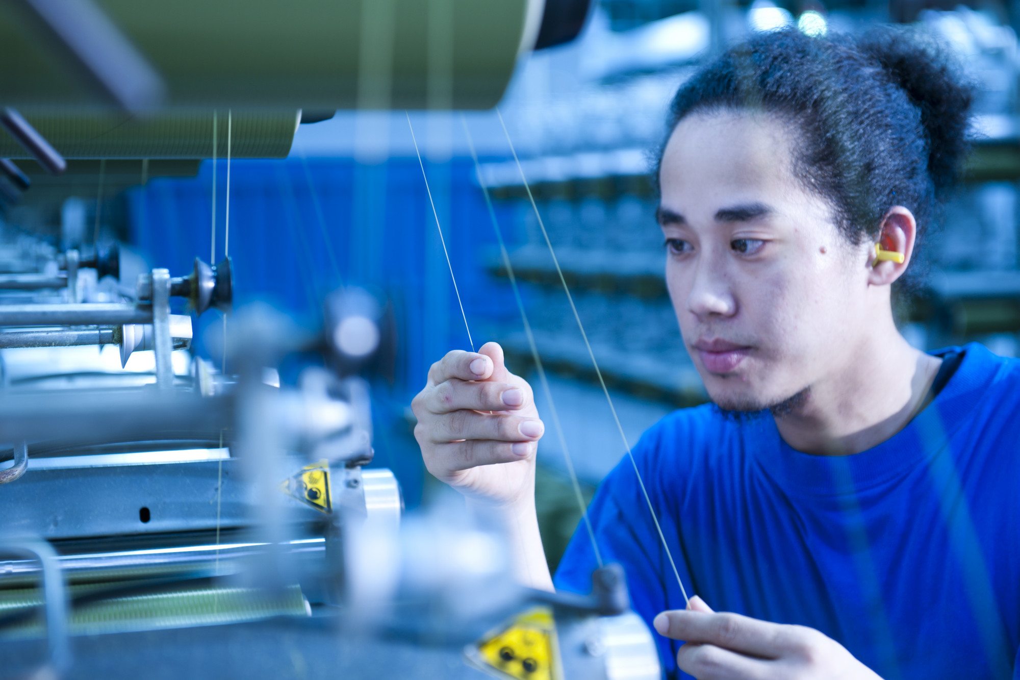 Operator inspecting yarn at a TenCate manufacturing facility